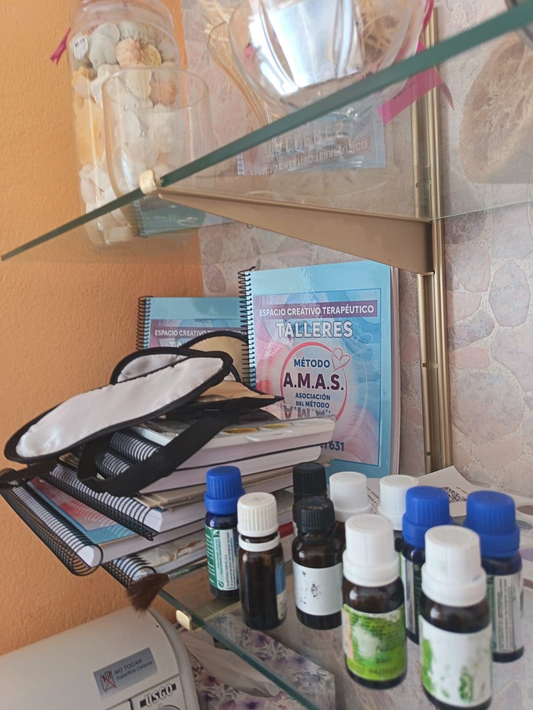 Frascos de aceites esenciales y un antifaz dispuestos sobre la mesa del taller