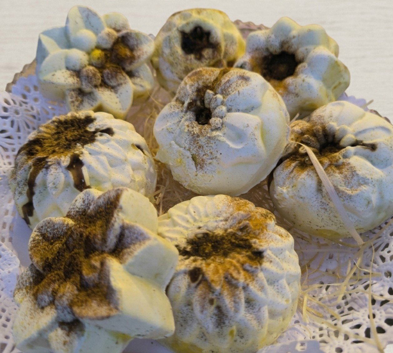 Jabones artesanales LETIJABONES con forma de pastelito y flores sobre un plato de encaje